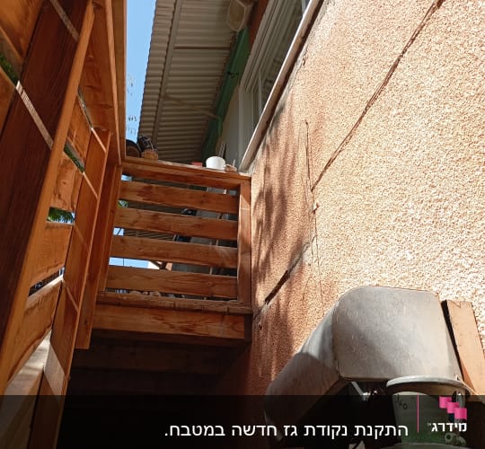 צילינדרים ירוקים ומבנה עץ ליד קיר חיצוני